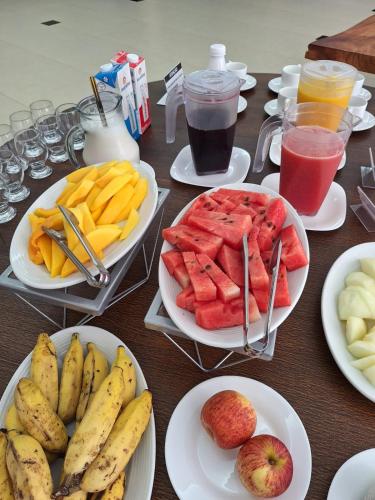 un tavolo ricoperto di piatti di frutta e bevande di Pousada Paraiso - Próximo a UFV a Viçosa