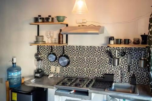 a kitchen with a stove and a patterned wall at Sayula HoME in Sayulita