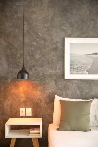 a bedroom with a bed and a table with a lamp at Sayula HoME in Sayulita