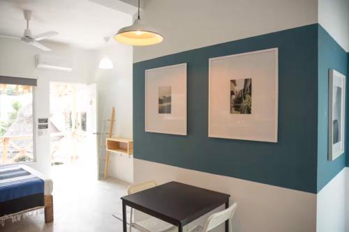 a living room with a blue accent wall and a table at Sayula HoME in Sayulita
