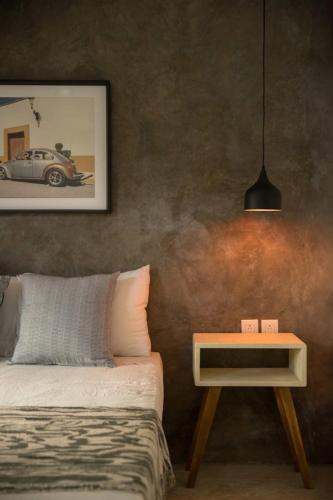 a bedroom with a bed and a side table at Sayula HoME in Sayulita