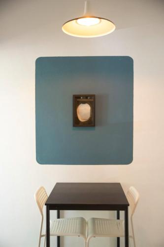 a table with two chairs and a light on a wall at Sayula HoME in Sayulita