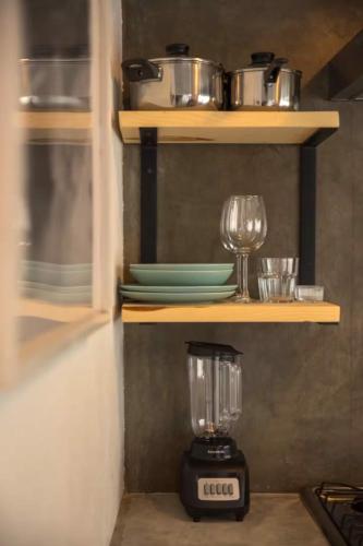a kitchen with a blender on a shelf with dishes at Sayula HoME in Sayulita