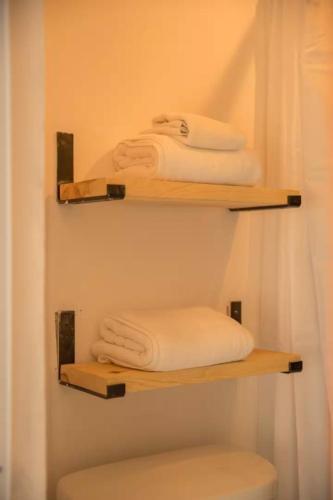 two shelves with towels on them in a bathroom at Sayula HoME in Sayulita