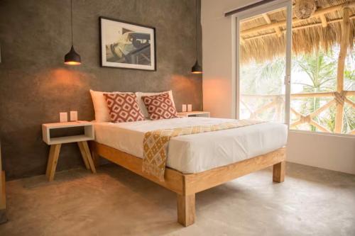 a bedroom with a large bed with a window at Sayula HoME in Sayulita