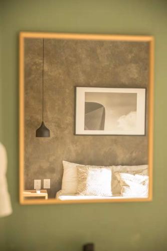 a framed picture above a bed with white pillows at Sayula HoME in Sayulita