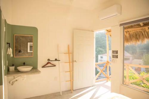 a bathroom with a sink and a window at Sayula HoME in Sayulita