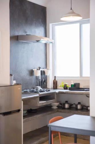 a kitchen with a sink and a table and a window at Sayula HoME in Sayulita