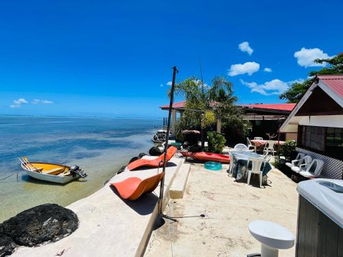 a beach with boats on the sand and a house at Pension Fare Hiro Moorea in Vaianae