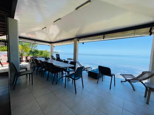 a restaurant with tables and chairs and a view of the ocean at Pension Fare Hiro Moorea in Vaianae
