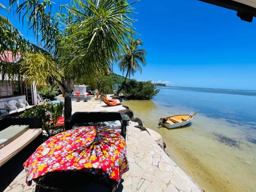an umbrella sitting on the beach next to the water at Pension Fare Hiro Moorea in Vaianae