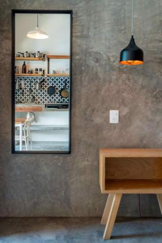 a mirror on a wall next to a table and a table sidx sidx at Sayula HoME in Sayulita