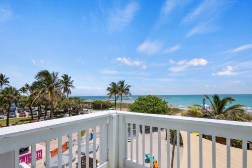 a balcony with a view of the beach and the ocean at Oceanfront Inn Room #15- Inlet View- King Bed in Fort Pierce