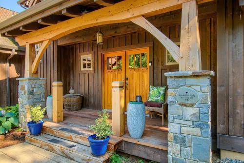 a front porch of a wooden house with plants at M-Hill Lodge Stevenson 98 in Stevenson
