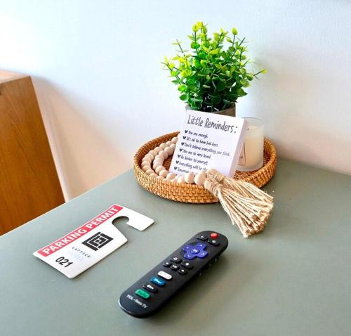 a remote control sitting on a table next to a plant at Salt City Retreat in Salt Lake City
