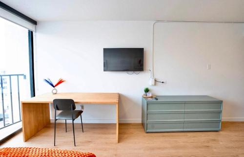 a room with a desk and a tv on a wall at Salt City Retreat in Salt Lake City