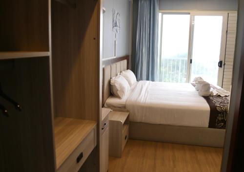 a small bedroom with a bed and a window at Yue Lai Hotel in Suva