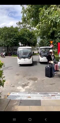 two white buses parked in a parking lot with luggage at Thong Dong Homestay in Phước Lý