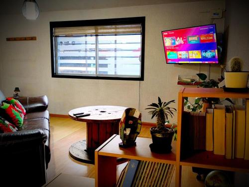 a living room with a table and a window at Casa equipada con estacionamiento privado y jardín in Tulancingo
