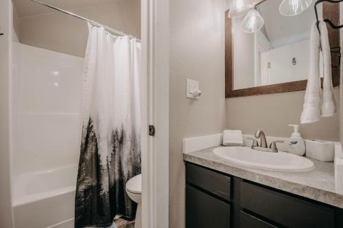 a bathroom with a sink and a toilet and a mirror at Snowater Condo 45SW with a Media Room in Deming
