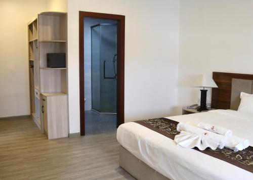 a bedroom with a bed and a walk in shower at Yue Lai Hotel in Suva