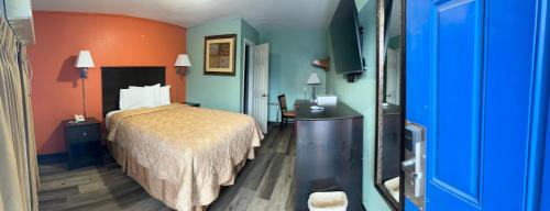 a hotel room with a bed and orange and blue walls at Town & Country Motel in Sioux City