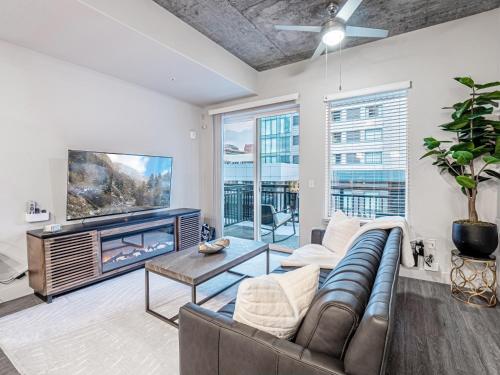 a living room with a couch and a tv at Designer - by Convention Center Pool, HTub, 24-7 Gym in Salt Lake City
