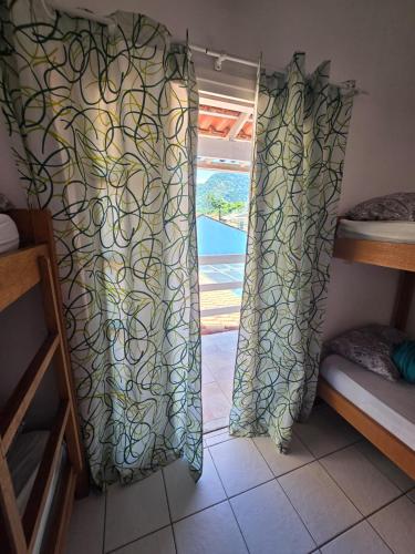 a window in a room with a curtain in front of it at Hostel ABC in Angra dos Reis