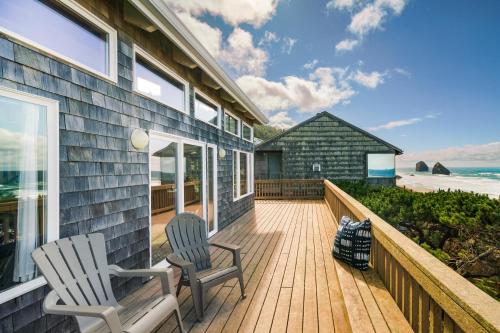 a house with two chairs on a deck with the beach at Pacific House in Cannon Beach