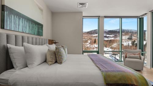 a bedroom with a large bed with a large window at Treehouse 409 EPIC 3 bed By Stowe Mountain Rentals in Stowe