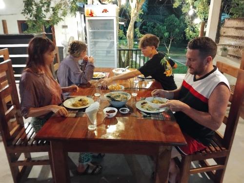 a group of people sitting around a table eating food at Pinnacle Safari Resort in Udawalawe