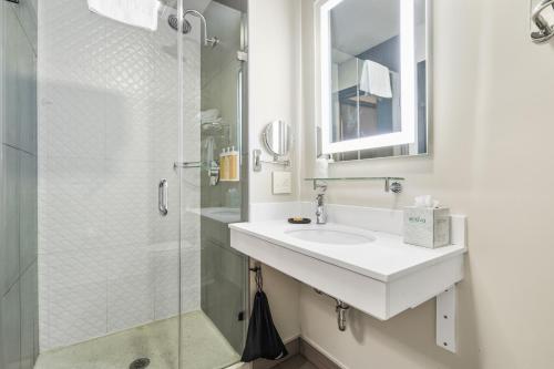 a white bathroom with a sink and a shower at Hotel EPIK in San Francisco