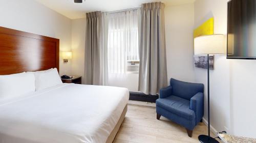 a hotel room with a bed and a blue chair at Comfort Inn Gaslamp Convention Center in San Diego