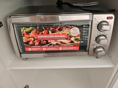 a toaster oven on a shelf with avertisement for at Luxury Villas en Monterrico in Monterrico