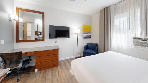 a hotel room with a bed and a desk and a mirror at Comfort Inn Gaslamp Convention Center in San Diego