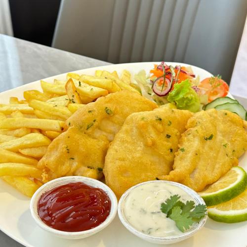 a plate of food with fish and chips and dip at Yue Lai Hotel in Suva