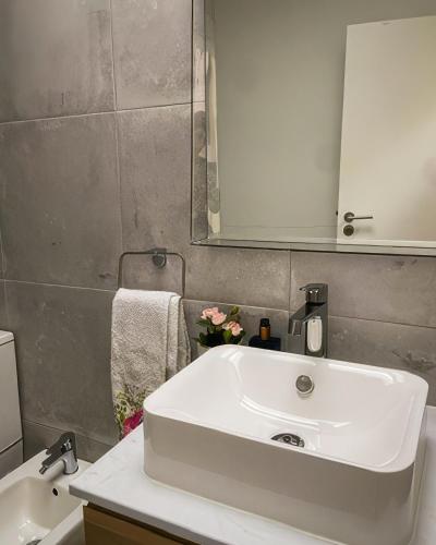 a bathroom with a white sink and a mirror at Casa de Miguel Chôco in Trancoso
