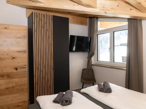 a bedroom with two beds and a tv on the wall at Tirolee Marchegg in Oberau