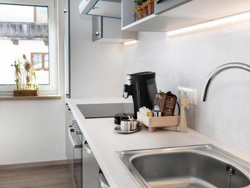 una cocina con fregadero y encimera en Tirolee Marchegg EG, en Wildschönau