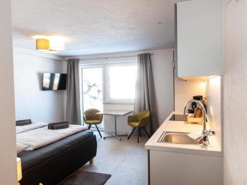 Habitación con cama y cocina con fregadero en Tirolee Marchegg EG, en Wildschönau