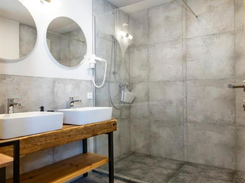 a bathroom with two sinks and a shower at Tirolee Marchegg EG Top 1 in Wildschönau