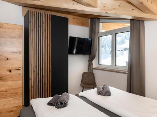 two beds in a room with a tv on the wall at Tirolee Marchegg 2 OG Top 4 in Oberau