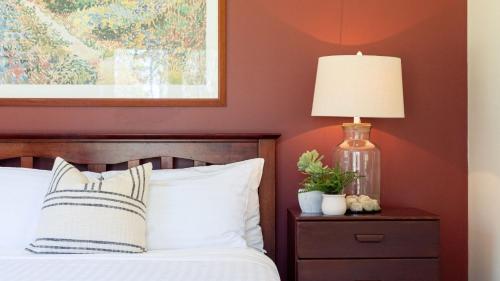 a bedroom with red walls and a bed with a lamp at Balmaghie in Bundanoon