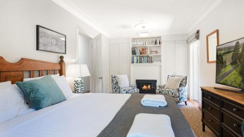 a bedroom with a large bed and a fireplace at Balmaghie in Bundanoon