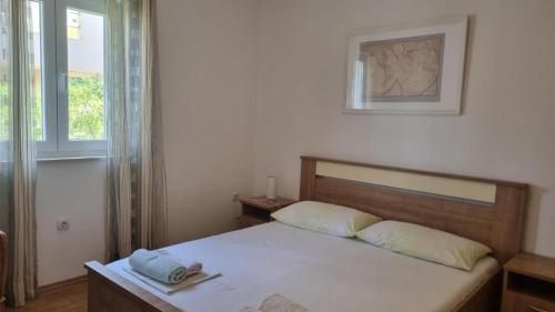 une chambre avec un lit avec une tête de lit en bois et une fenêtre dans l'établissement Apartment Relax, à Mandre