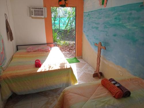 ein Zimmer mit 2 Betten und einem Fenster und ein Zimmer mit einem Zimmer in der Unterkunft Cabaña de Lucas in Loma Bonita