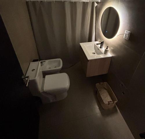 un bagno con un water, un lavandino e uno specchio di casa moderna a Durazno