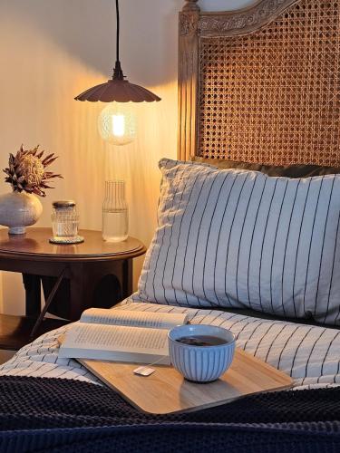 a bed with a wooden tray with a bowl on it at Country Style in the City - Close to Airport in Sydney