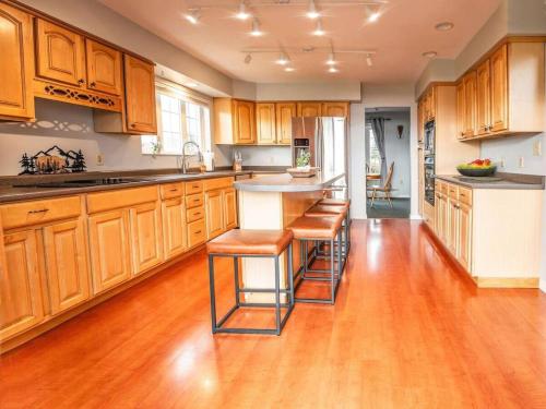 a kitchen with wooden cabinets and a island with bar stools at Lake House in Newport Maine in Loon Island