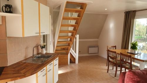 a kitchen with a spiral staircase and a dining room at Chalet Vue Lac in Chaillac